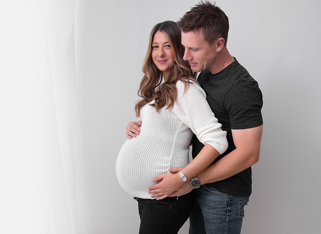 couple maternity shoot - jeans and jumper, white background