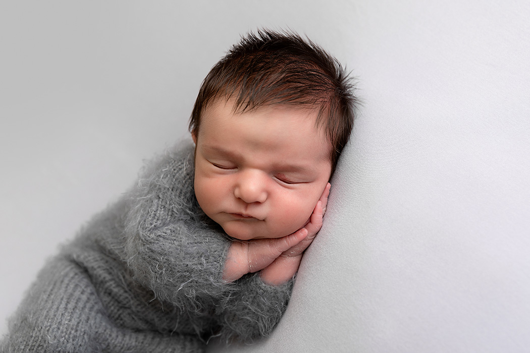 newborn baby boy in grey knitted romper