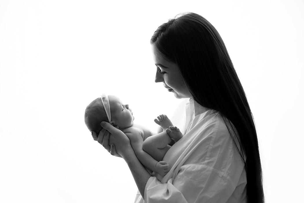 backlit photo of mum holding newborn baby girl